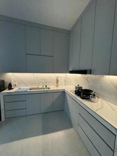 a kitchen with white cabinets and a sink at Monde Residence Block K number 17 in Bagam