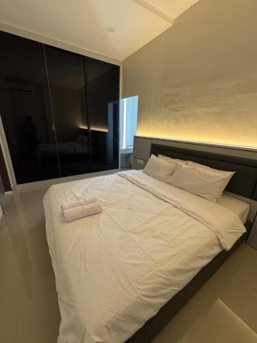a large white bed with a towel on it at Monde Residence Block K number 17 in Bagam