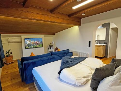 a bedroom with two beds and a blue couch at Boutique-Pension Jägerwirt in Scheffau am Wilden Kaiser