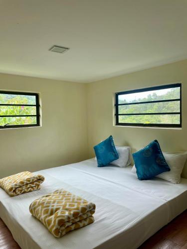 a bedroom with two beds with blue pillows at Forest Lodge, Radiant Janda Baik in Bentong