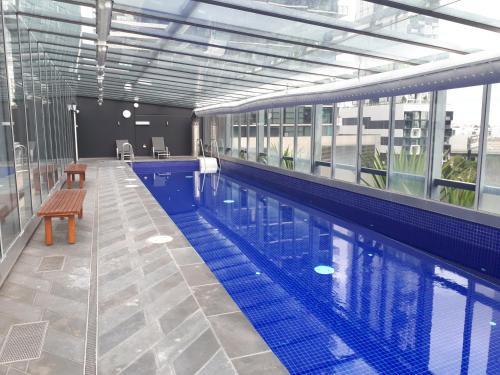 a swimming pool with a bench in a building at Exclusive Stays - Vue Grande in Melbourne