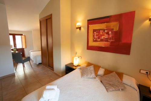 a bedroom with a bed and a painting on the wall at Hotel Rural L'Antic Portal in Vilafames