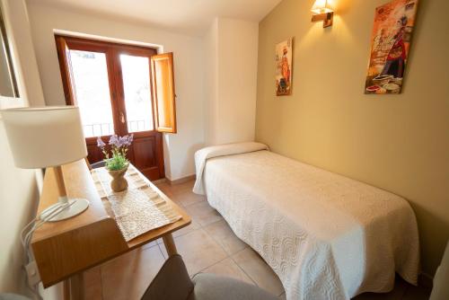 a bedroom with a bed and a table with a lamp at Hotel Rural L'Antic Portal in Vilafames