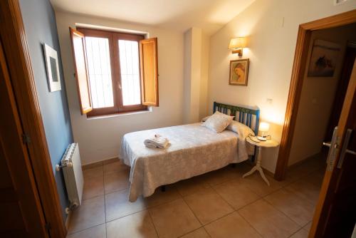 a small bedroom with a bed and a window at Hotel Rural L'Antic Portal in Vilafames