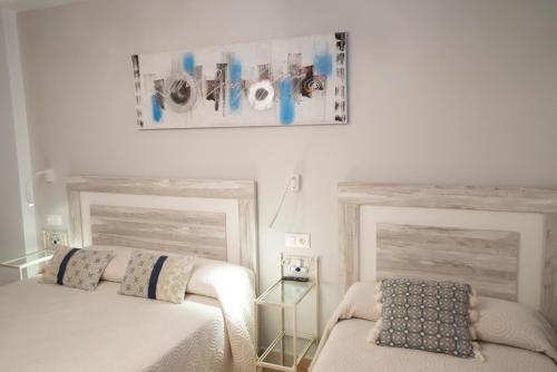 a bedroom with two beds and a picture on the wall at Hotel Rural L'Antic Portal in Vilafames