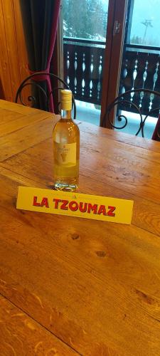 a bottle of alcohol sitting on top of a wooden table at LA TZOUMAZ - VERBIER 4 Vallées - Grand Chalet 5 chambres, Ski IN/OUT, Sauna in La Tzoumaz
