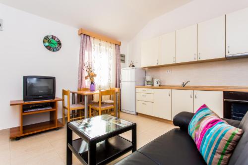 a living room with a couch and a table and a kitchen at Lavanda 3 in Njivice