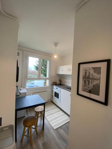 - une cuisine avec un bureau, une table et des chaises dans l'établissement Appartement cosy entre Paris et Disneyland Paris, à Villiers-sur-Marne