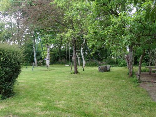 a park with a swing set in the grass at Chambres d'Hôtes de la Ferme Auberge de Mésauboin in Billé