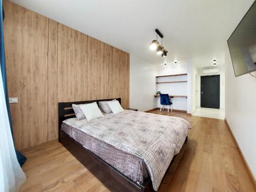 una camera da letto con un letto grande con una parete in legno di Новобудова Місто Трав, р-н Вікторії Гарденс a Lviv
