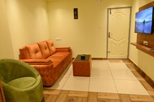 a living room with a couch and a chair at Cous Cous Residency Hotel in Padinjarathara