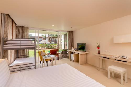 a bedroom with a bed and a desk with a computer at The Briza Beach Resort, Khao Lak SHA Extra Plus in Khao Lak