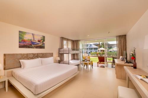 a hotel room with a bed and a dining area at The Briza Beach Resort, Khao Lak SHA Extra Plus in Khao Lak