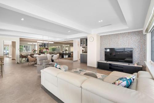 a living room with a white couch and a tv at Exquisite Oasis Family Retreat in Perth