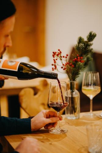 a person pouring wine into a wine glass at Salzbergalm in Berchtesgaden