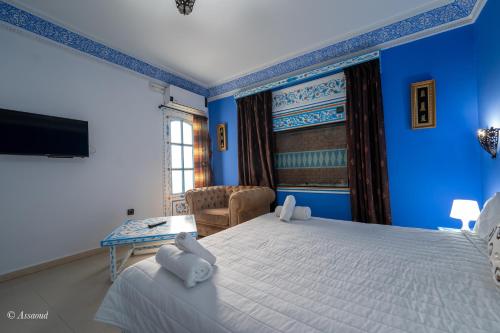 a bedroom with blue walls and a large bed at Casa Familia in Chefchaouene