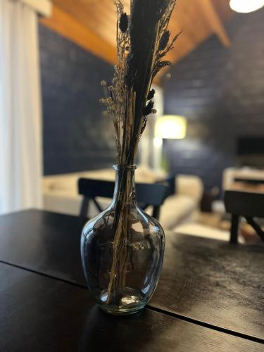 a glass vase with flowers sitting on a table at Le Chalet des Sœurs in Namur
