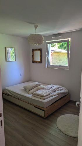 une chambre avec un lit dans une pièce avec une fenêtre dans l'établissement Wooden house, à Douarnenez