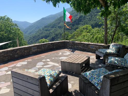a patio with a flag and chairs and a flag at Magic Mola in Zeri