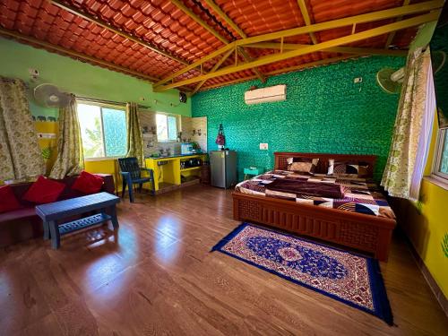 a bedroom with a bed and a green wall at MangoHut Farmhouse Pool Villa in Hyderabad