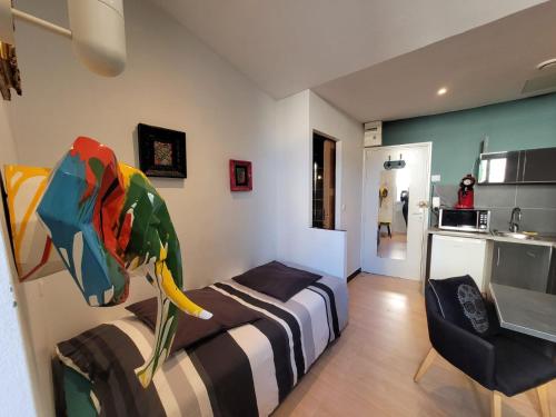 une chambre avec un lit et une chaise et une cuisine dans l'établissement Studio calme et chaleureux Aix centre, à Aix-les-Bains