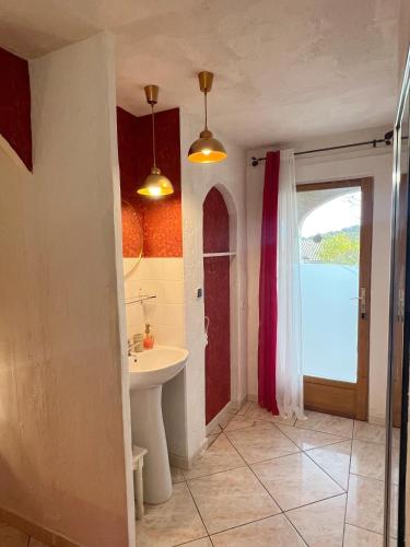 La salle de bains est pourvue d'un lavabo et d'une porte avec fenêtre. dans l'établissement Bed & Breakfast Le Beauséjour, à Carcassonne