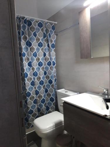 a bathroom with a toilet and a sink and a shower at Lovely House in Mytilene
