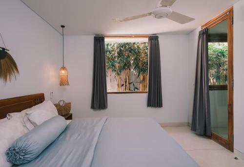 a bedroom with a bed and a window at Marlaca Villas Lombok in Kuta Lombok