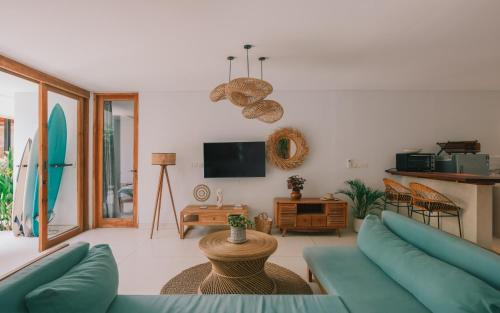 a living room with a couch and a tv at Marlaca Villas Lombok in Kuta Lombok