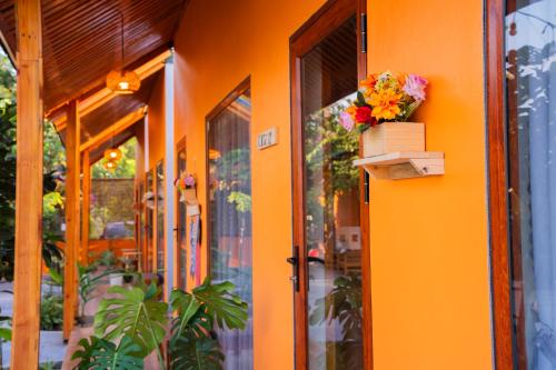 an orange building with a box of flowers on it at Rosa Garden in Ninh Binh