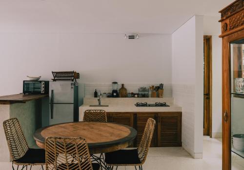 a kitchen with a table and chairs and a refrigerator at Marlaca Villas Lombok in Kuta Lombok