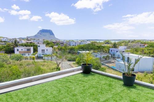 - une vue depuis le balcon d'une maison avec de l'herbe et des plantes dans l'établissement Palms 2, à La Gaulette