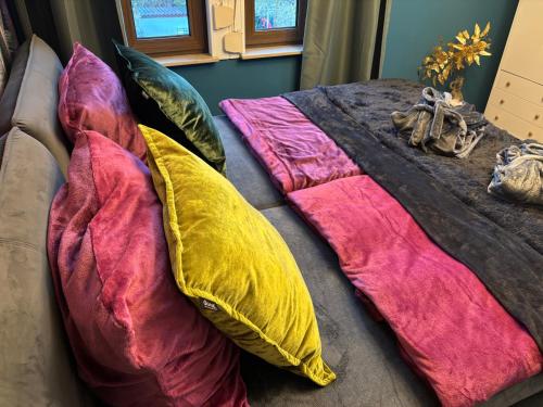 a bed with colorful pillows on top of it at Haus Hannah in Meiningen