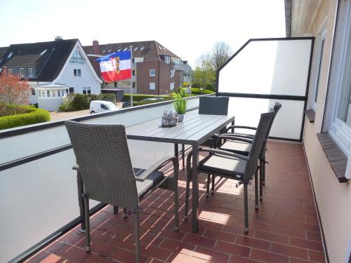 a patio table and chairs on a balcony at Ferienwohnungen mit "Strandfeeling" Waldstraße 15 Kellenhusen Ostsee in Kellenhusen