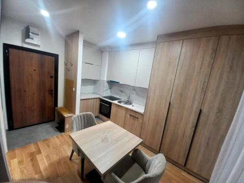 a small kitchen with a table and chairs in a room at MN apartman in Banja Luka