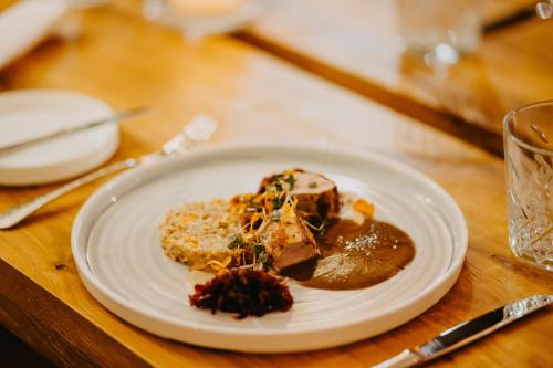 a white plate with food on a wooden table at Salzbergalm in Berchtesgaden