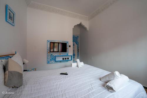a bedroom with a white bed and a mirror at Casa Familia in Chefchaouene