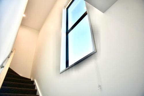 a staircase with a window and a swing at Modern 3BR Escape 3 Private Baths Rare Garage Perfect for Groups in Christchurch
