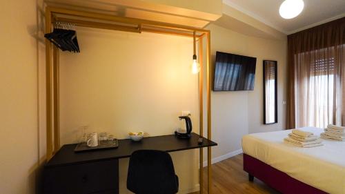 ローマにあるSuites 51の机とベッドのあるホテルの部屋