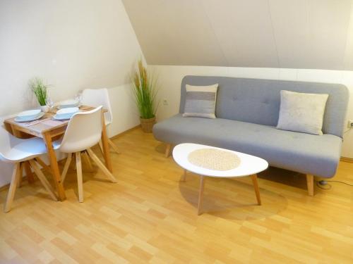 a living room with a blue couch and a table at Ferienwohnungen mit "Strandfeeling" Waldstraße 15 Kellenhusen Ostsee in Kellenhusen