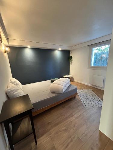 une chambre avec un grand lit avec un mur noir dans l'établissement T2 cosy - jardin des plantes, à Montauban