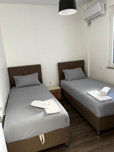 dwa łóżka w małym pokoju z dwoma ręcznikami na nich w obiekcie Amore w Ulcinju