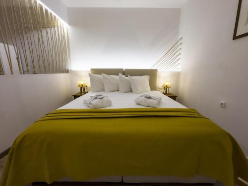 a bedroom with a large bed with a yellow blanket at PS Apartment Polydrosos - PS Rental in Polydrossos