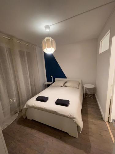 a bedroom with a white bed and a blue wall at L'Écrin Bleu in Saint-Gaudens