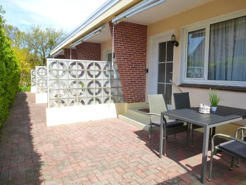 a patio with a table and chairs in front of a house at Ferienwohnungen mit "Strandfeeling" Waldstraße 15 Kellenhusen Ostsee in Kellenhusen