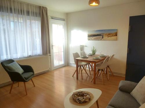 a living room with a table and chairs at Ferienwohnungen mit "Strandfeeling" Waldstraße 15 Kellenhusen Ostsee in Kellenhusen