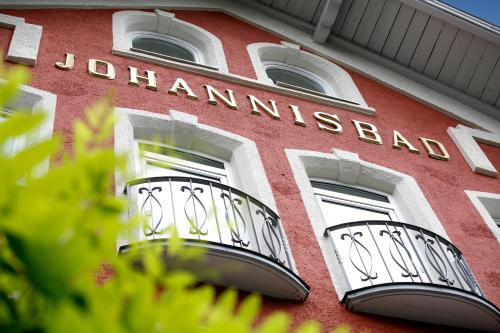 a building with two balconies and a sign on it at Hotel Johannisbad in Bad Aibling