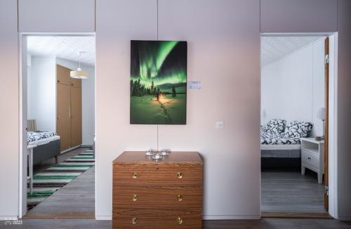 a room with a dresser and a picture on the wall at Perinteikäs 3 makuuhuoneen koti in Kainuu