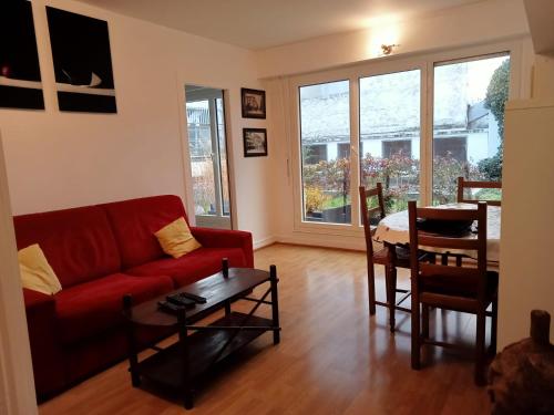 un salon avec un canapé rouge et une table dans l'établissement Appartement 11e, à Paris