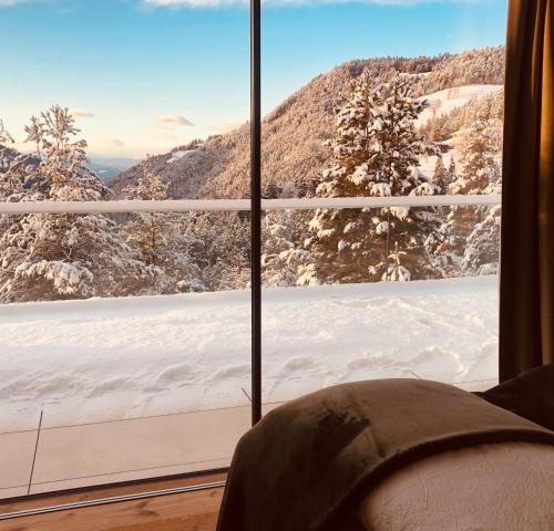 a view of a snow covered mountain from a window at Chalet Tschattlhof Dolomites in Ponte Nova